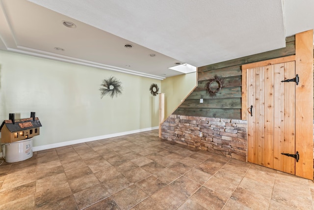 spare room featuring wooden walls and a skylight