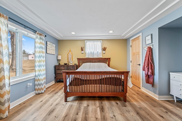 bedroom with multiple windows and light hardwood / wood-style flooring