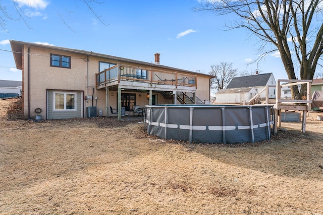 back of property featuring central AC unit and a swimming pool side deck