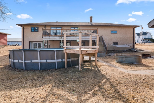 rear view of house with a pool side deck