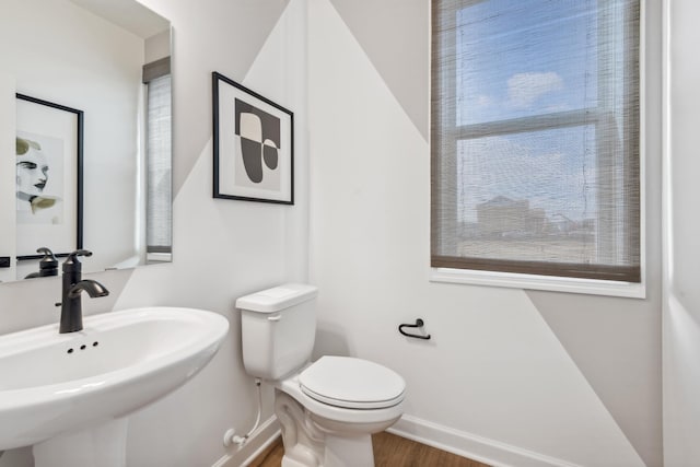 bathroom featuring sink, a wealth of natural light, and toilet