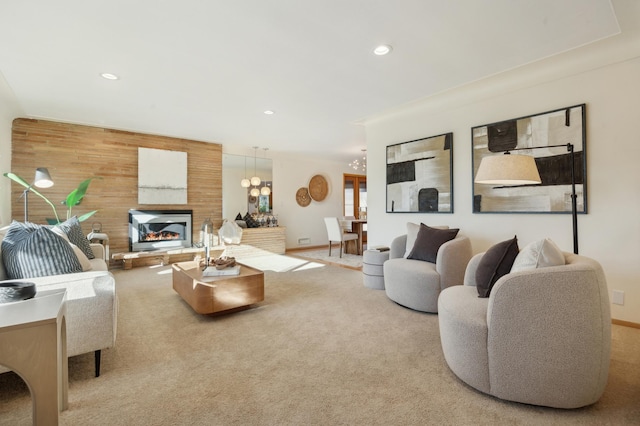 carpeted living room featuring a notable chandelier and wood walls