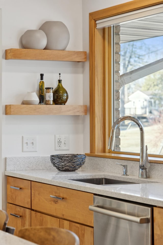 interior details with light stone counters, sink, and stainless steel dishwasher