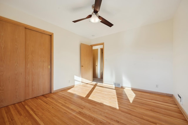 unfurnished bedroom featuring hardwood / wood-style flooring, a closet, and ceiling fan