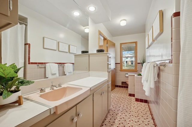 bathroom featuring vanity and tile walls