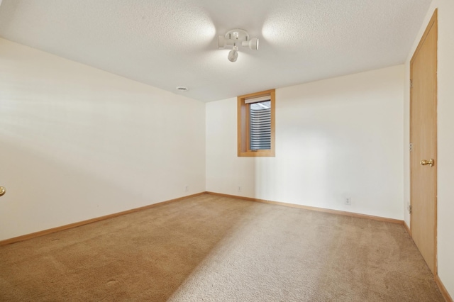 empty room with light colored carpet and a textured ceiling