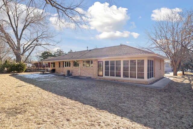 rear view of house featuring a sunroom, a patio area, and central air condition unit