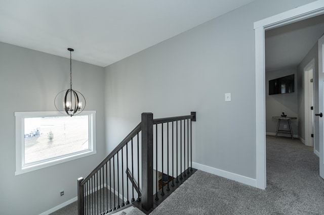 stairway with carpet flooring and an inviting chandelier