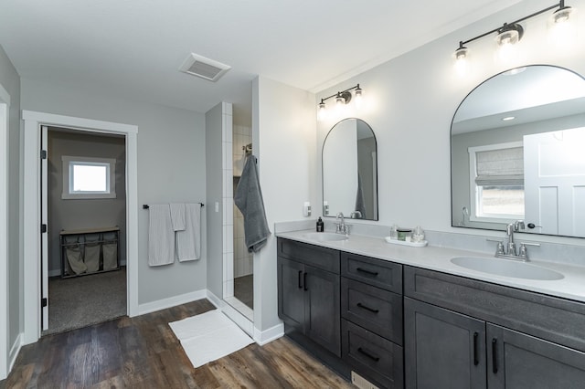 bathroom with vanity, a wealth of natural light, wood-type flooring, and walk in shower