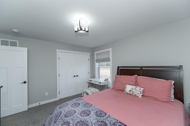 bedroom with a textured ceiling, a closet, and dark colored carpet