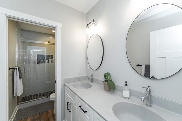 bathroom featuring vanity, hardwood / wood-style floors, toilet, and walk in shower