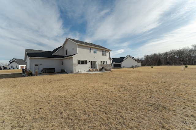 back of house featuring a yard, central AC unit, and a patio area