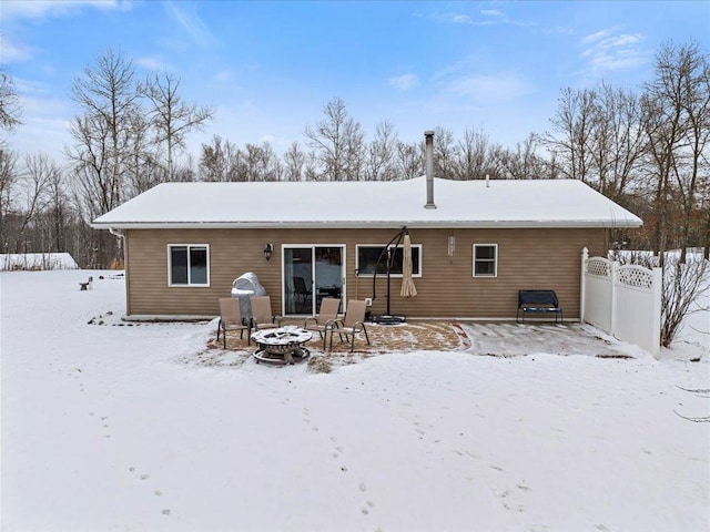 snow covered house featuring a fire pit