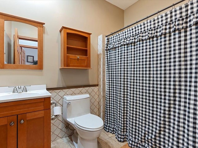 bathroom with tile patterned floors, vanity, tile walls, and toilet