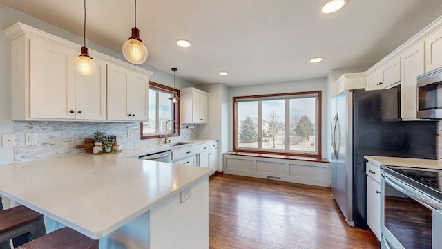 kitchen featuring hanging light fixtures, kitchen peninsula, white cabinets, and a kitchen bar