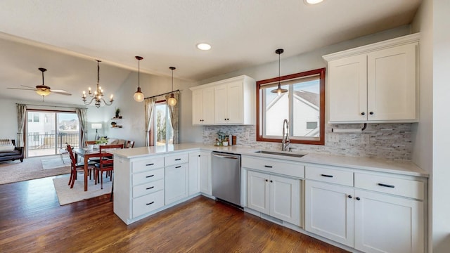 kitchen with sink, white cabinets, decorative light fixtures, stainless steel dishwasher, and kitchen peninsula