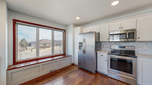 kitchen with white cabinetry, appliances with stainless steel finishes, and backsplash