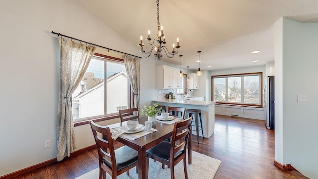 dining room with lofted ceiling, dark wood-type flooring, and an inviting chandelier