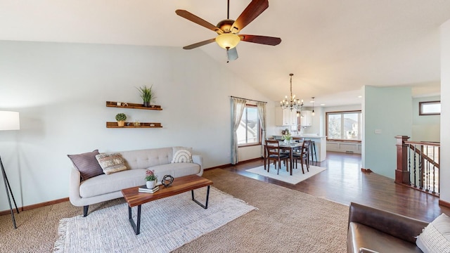 living room featuring ceiling fan with notable chandelier, vaulted ceiling, and dark hardwood / wood-style floors