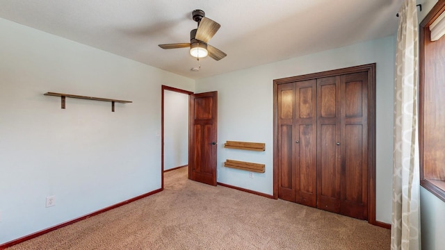 unfurnished bedroom featuring ceiling fan, light colored carpet, and a closet