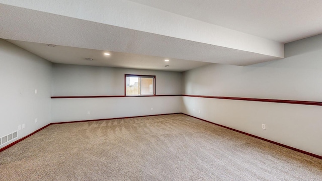 carpeted empty room featuring a textured ceiling