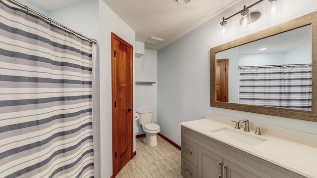 bathroom with a shower with curtain, vanity, a textured ceiling, and toilet