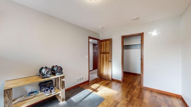 unfurnished bedroom featuring dark wood-type flooring and a walk in closet