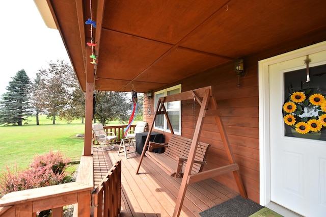 wooden terrace with a yard and a porch