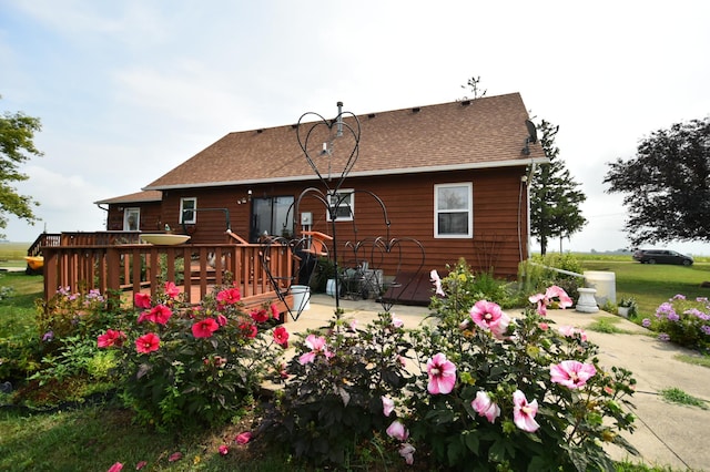 rear view of property with a wooden deck and a patio area