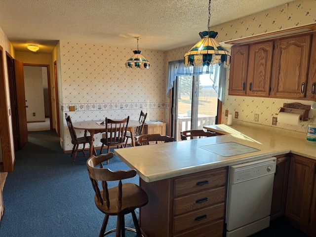 kitchen with a breakfast bar, dishwasher, hanging light fixtures, a textured ceiling, and kitchen peninsula