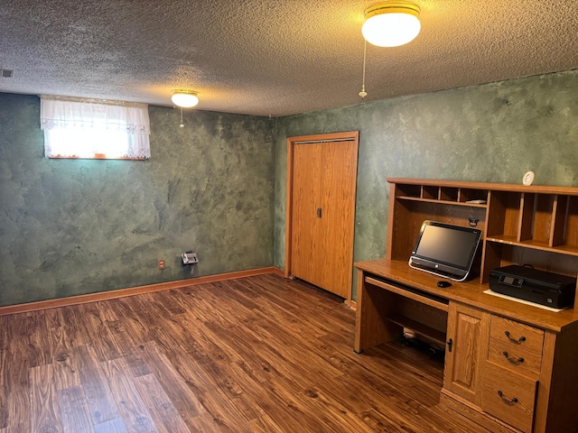 unfurnished office with dark wood-type flooring and a textured ceiling