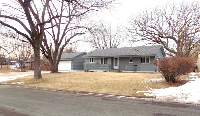 ranch-style home featuring a garage and a yard