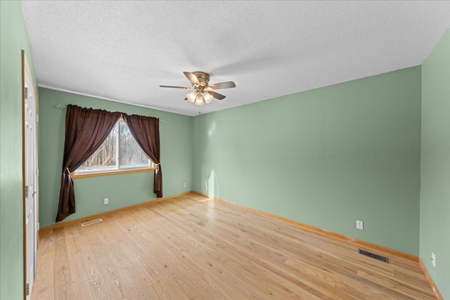 empty room with ceiling fan, a textured ceiling, and light hardwood / wood-style floors