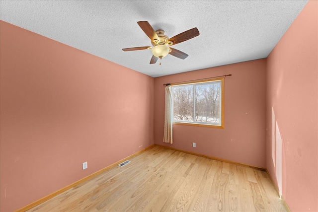 empty room featuring ceiling fan, a textured ceiling, and light wood-type flooring