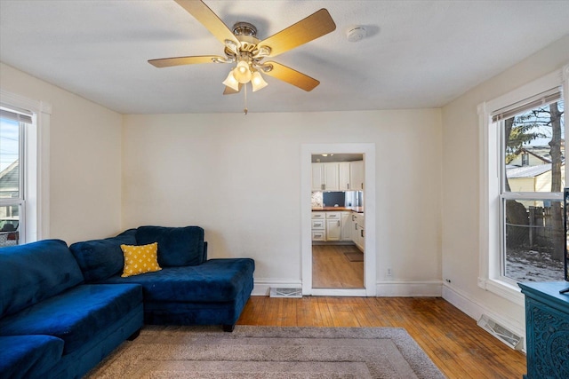 living room with wood-type flooring and ceiling fan