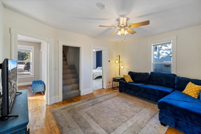 living room with a textured ceiling, wood-type flooring, and ceiling fan