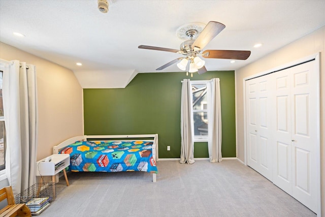 carpeted bedroom featuring vaulted ceiling, ceiling fan, and a closet