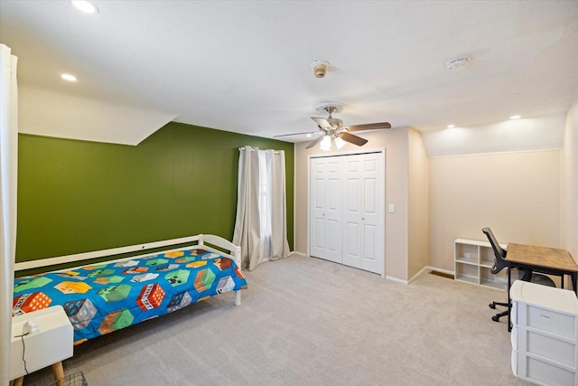 bedroom with lofted ceiling, light colored carpet, ceiling fan, and a closet