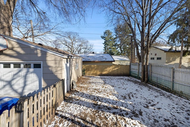 yard layered in snow with a garage