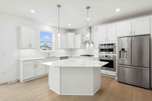 kitchen featuring white cabinetry, sink, decorative light fixtures, and appliances with stainless steel finishes