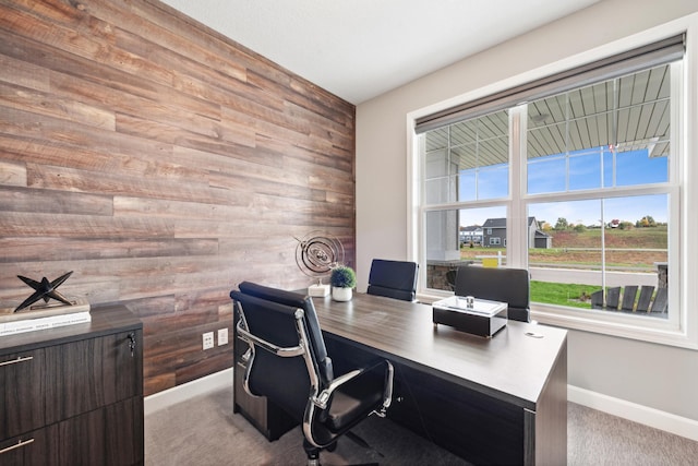 carpeted office space featuring wooden walls