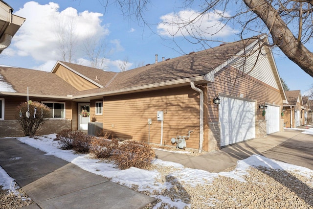 snow covered property with central AC unit