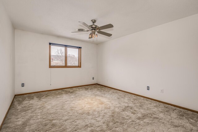 empty room featuring ceiling fan, baseboards, visible vents, and carpet floors