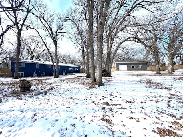 yard covered in snow featuring a garage