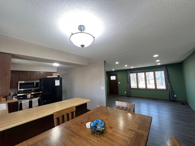 dining space featuring recessed lighting, dark wood-style flooring, and a textured ceiling