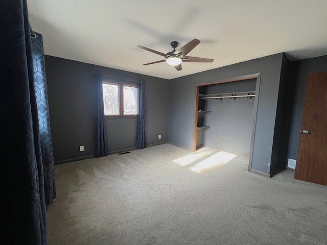 unfurnished bedroom with a ceiling fan, carpet, visible vents, baseboards, and a closet