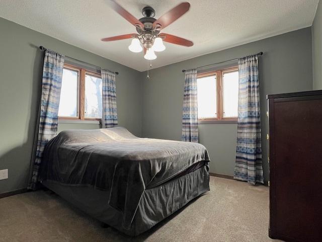 carpeted bedroom featuring baseboards, multiple windows, and a textured ceiling