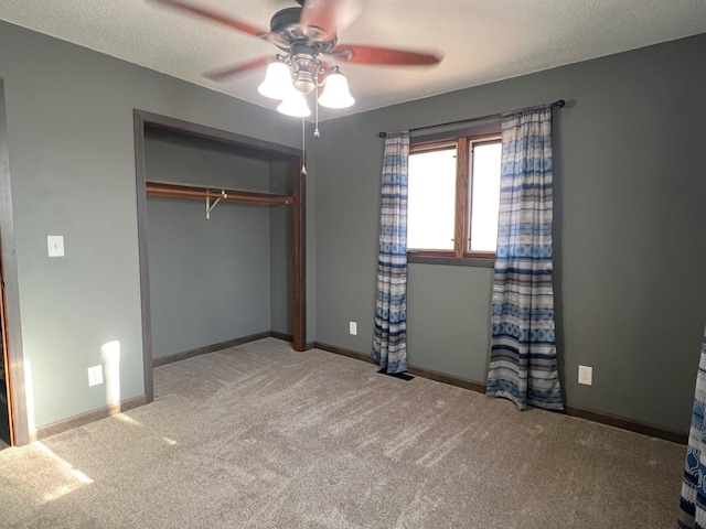 unfurnished bedroom featuring carpet flooring, baseboards, a closet, and a textured ceiling