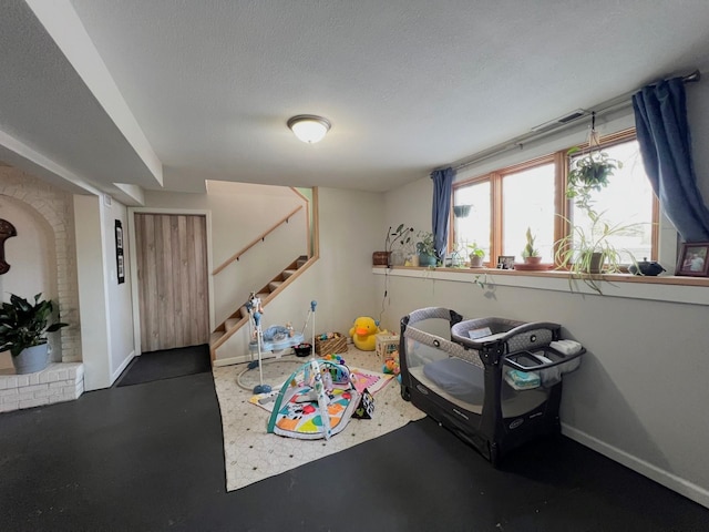 rec room with baseboards and a textured ceiling