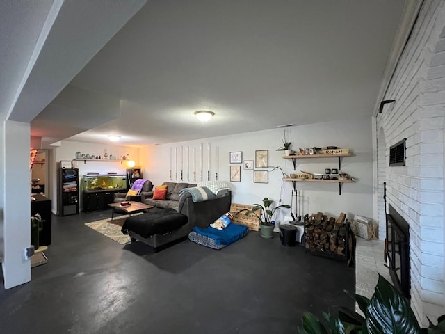 living area featuring finished concrete flooring, a fireplace, and visible vents